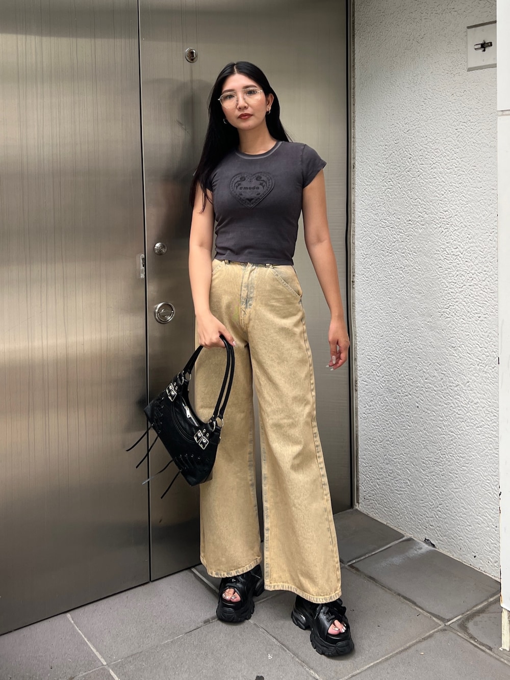 ブラック系のTシャツ/カットソー、ベージュ系のデニムパンツ、ブラック系のサンダルを着用したレディースの夏コーディネートの1枚目の写真