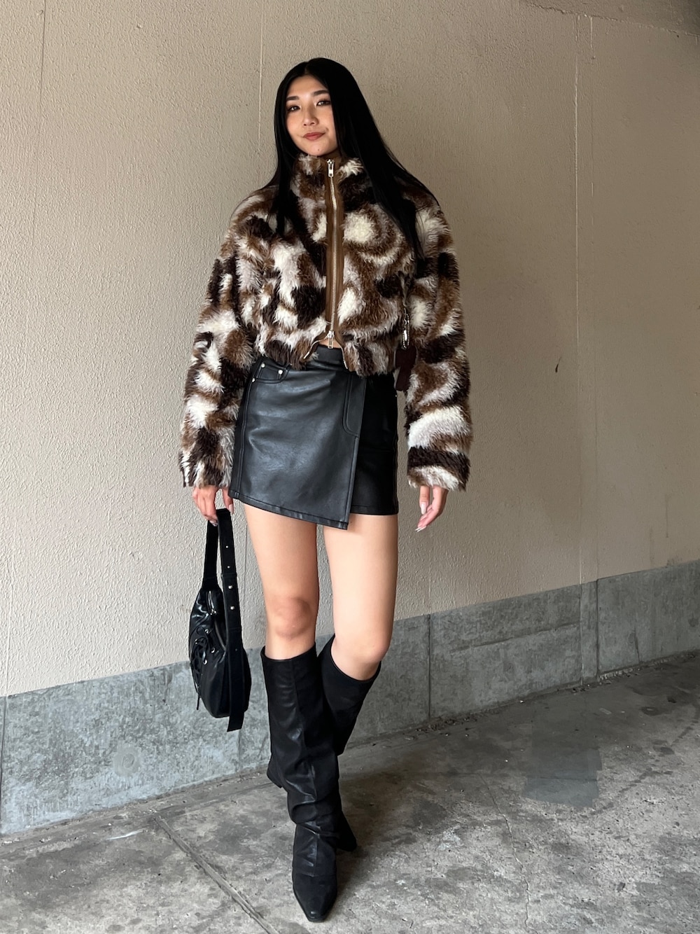 ブラウン系のブルゾン、ブラック系のスカート、ブラック系のブーツを着用したレディースの冬コーディネートの1枚目の写真