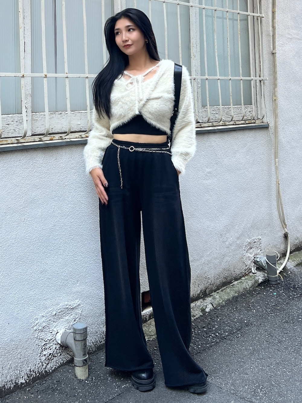 ブラック系のスウェットパンツ、ブラウン系のブーツ、ブラック系のキャミソールを着用したレディースの秋コーディネートの1枚目の写真