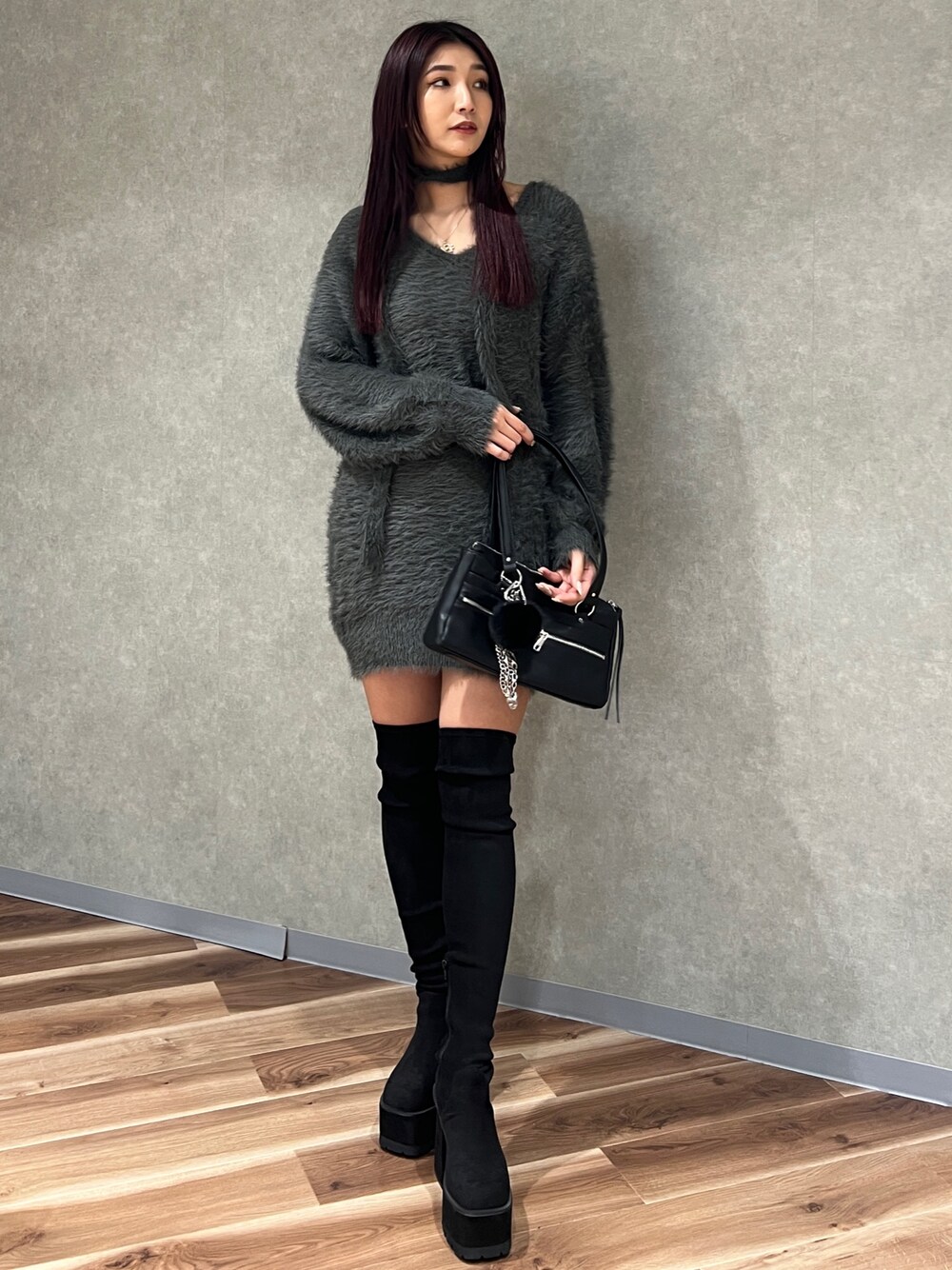 グレー系のワンピース、ブラック系のショルダーバッグ、ブラック系のブーツを着用したレディースの秋コーディネートの1枚目の写真