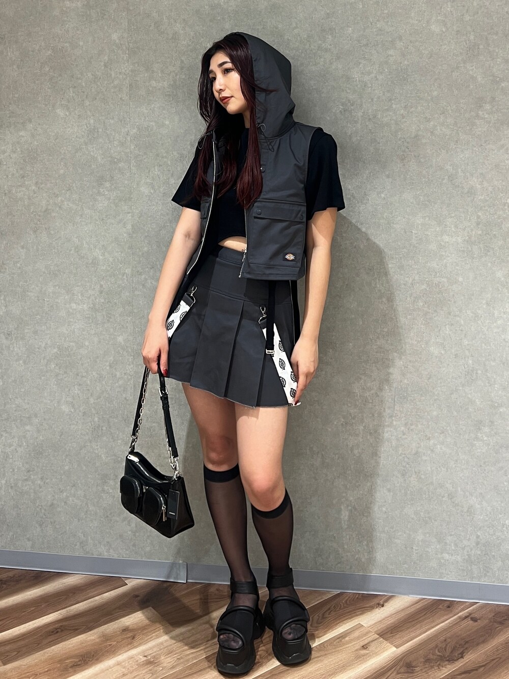 グレー系のベスト、ブラック系のTシャツ/カットソー、グレー系のスカートを着用したレディースの春コーディネートの1枚目の写真