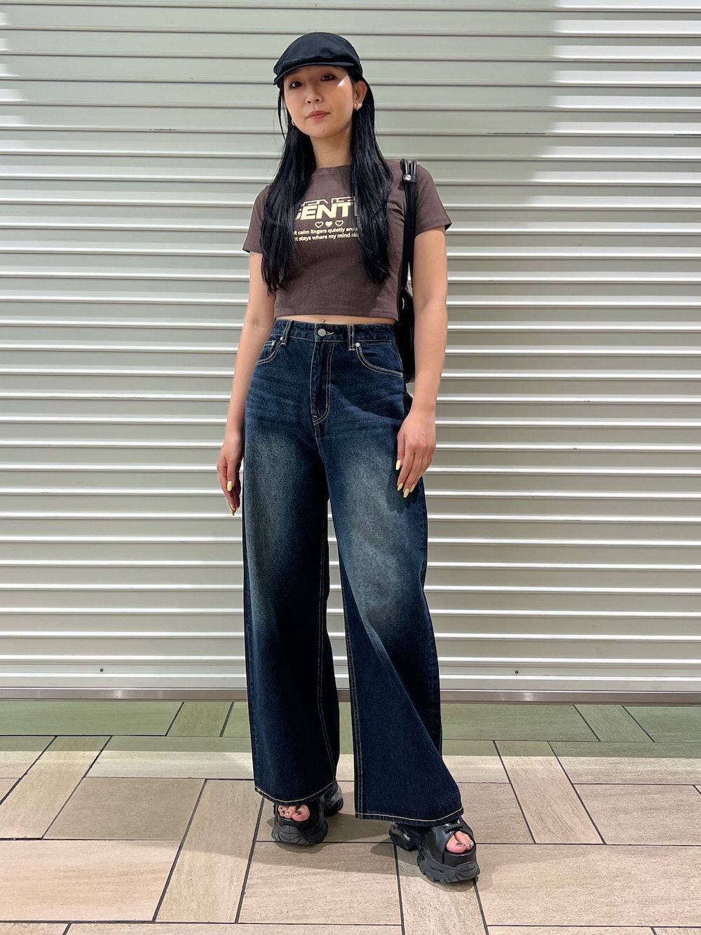 ブラウン系のTシャツ/カットソー、ブルー系のデニムパンツ、ブラック系のサンダルを着用したレディースの春コーディネートの1枚目の写真