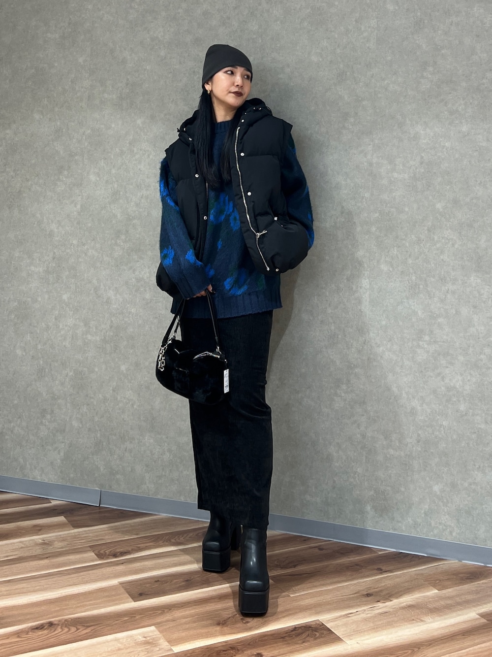 ブルー系のニット/セーター、ブラック系のブルゾン、ブラック系のスカートを着用したレディースの秋コーディネートの1枚目の写真