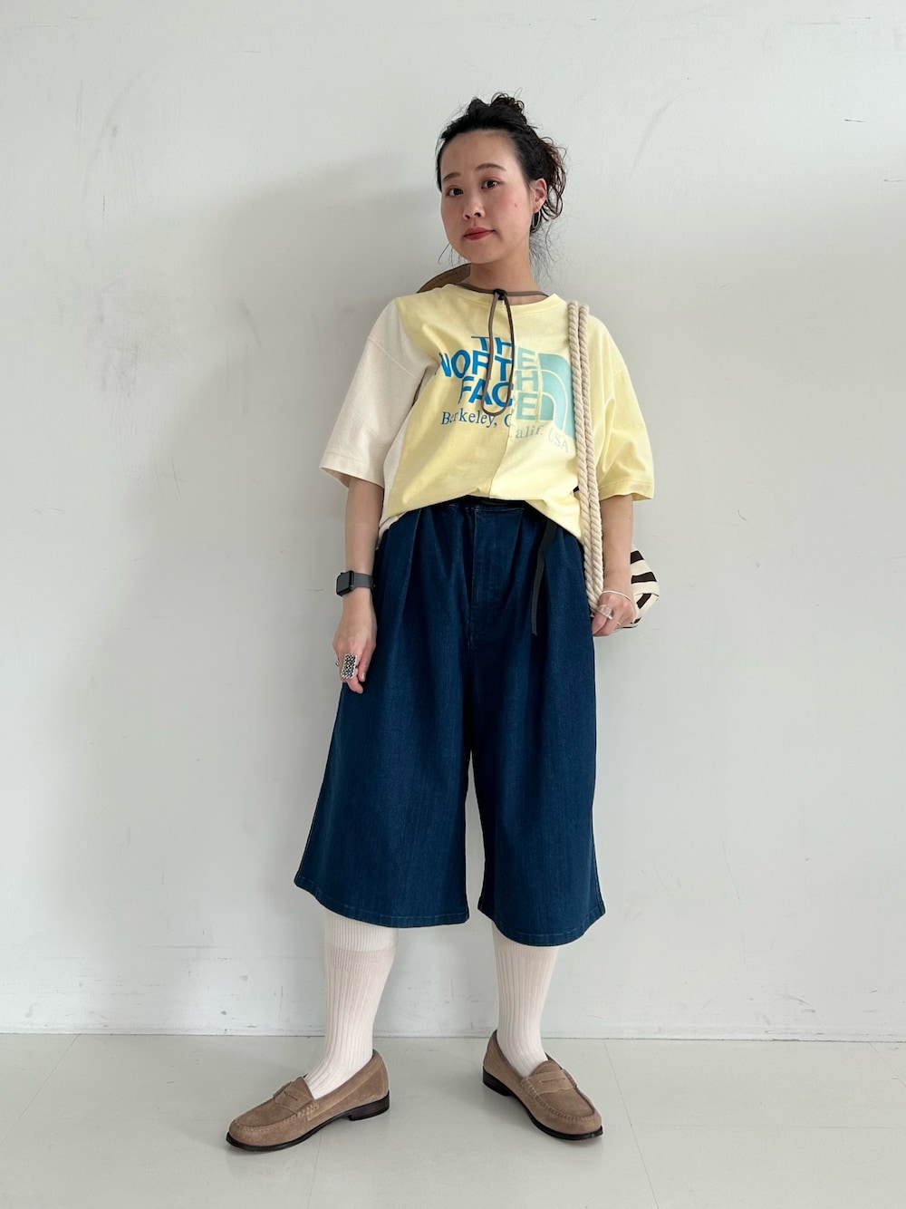 ブラウン系のバックパック/リュック、ブルー系のデニムパンツ、ベージュ系のローファーを着用したレディースの春コーディネートの1枚目の写真