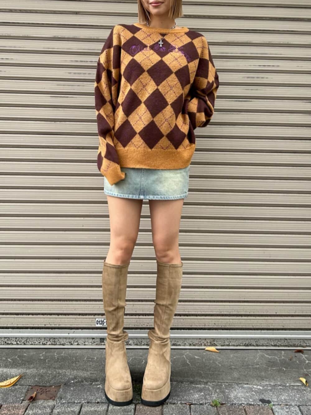 ブルー系のデニムスカート、ブラウン系のニット/セーター、ベージュ系のブーツを着用したレディースの秋コーディネートの1枚目の写真