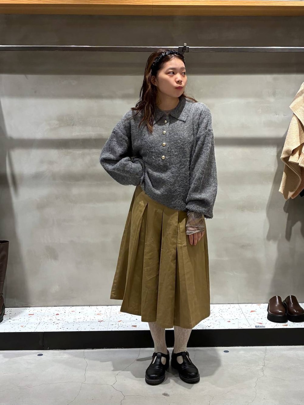 ベージュ系のチノパンツ、グレー系のニット/セーター、イエロー系のTシャツ/カットソーを着用したレディースの秋コーディネートの1枚目の写真