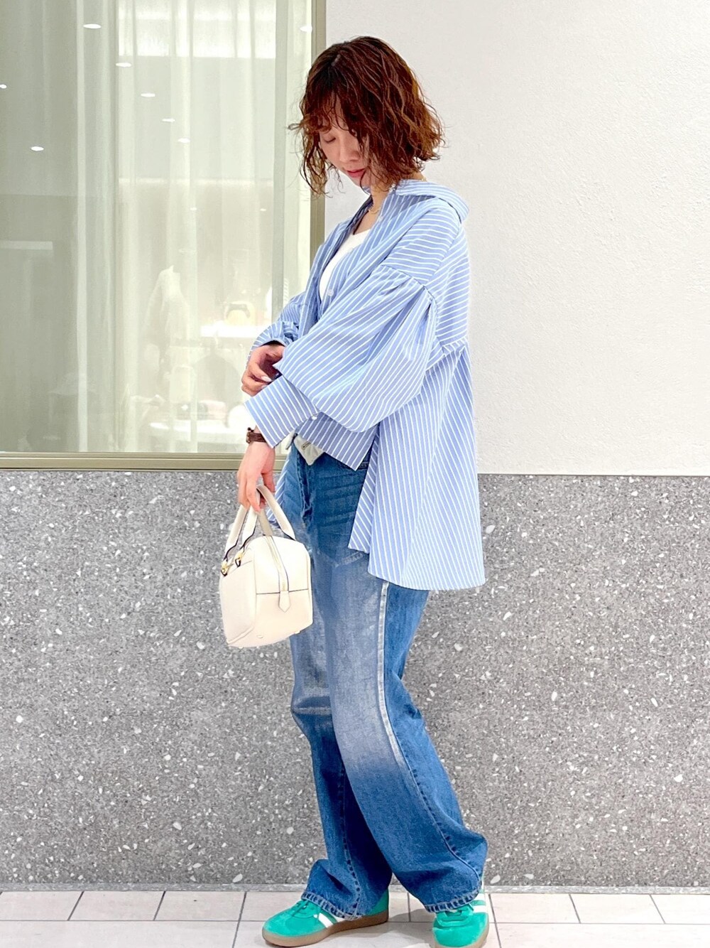 ブルー系のデニムパンツ、ブルー系のシャツ/ブラウス、ホワイト系のボストンバッグを着用したレディースの春コーディネートの1枚目の写真