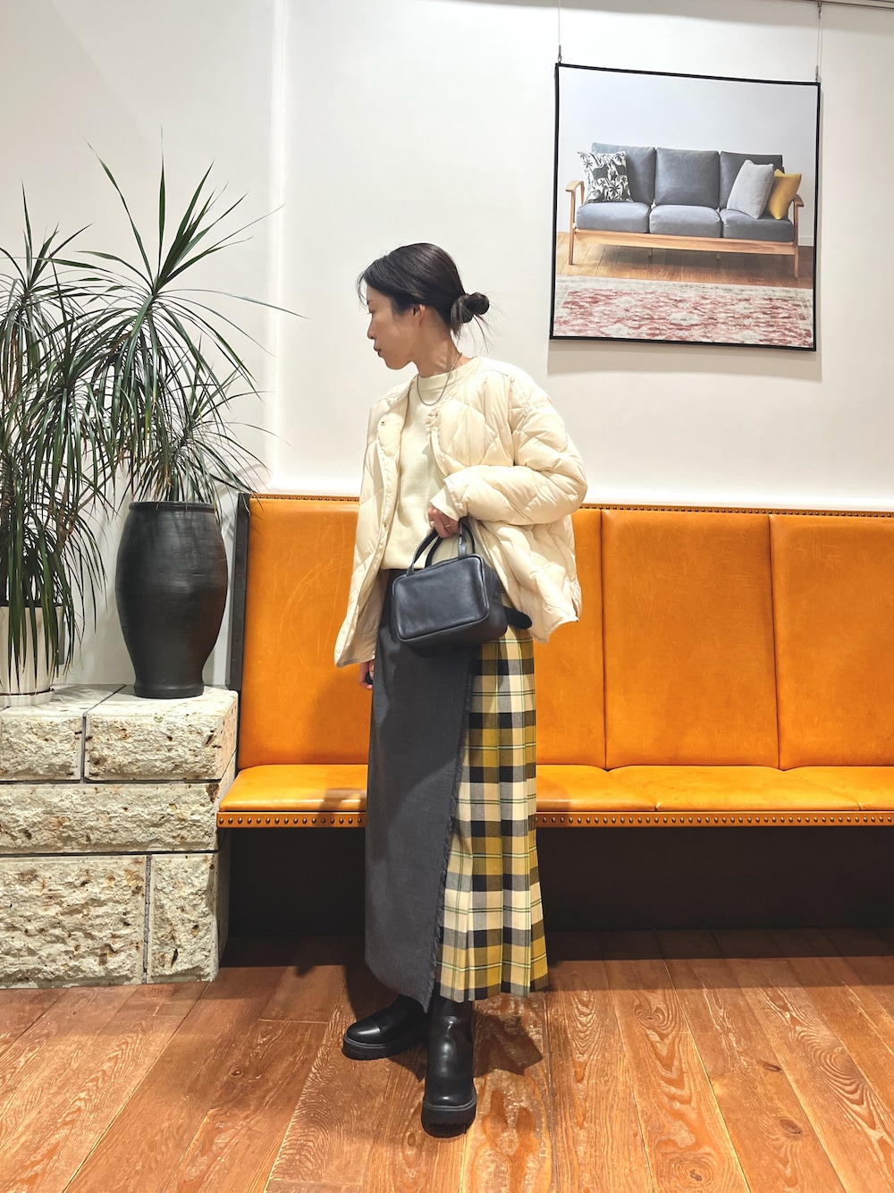 ブラック系のボストンバッグ、ホワイト系のダウンジャケット/コート、ホワイト系のニット/セーターを着用したレディースの冬コーディネートの1枚目の写真