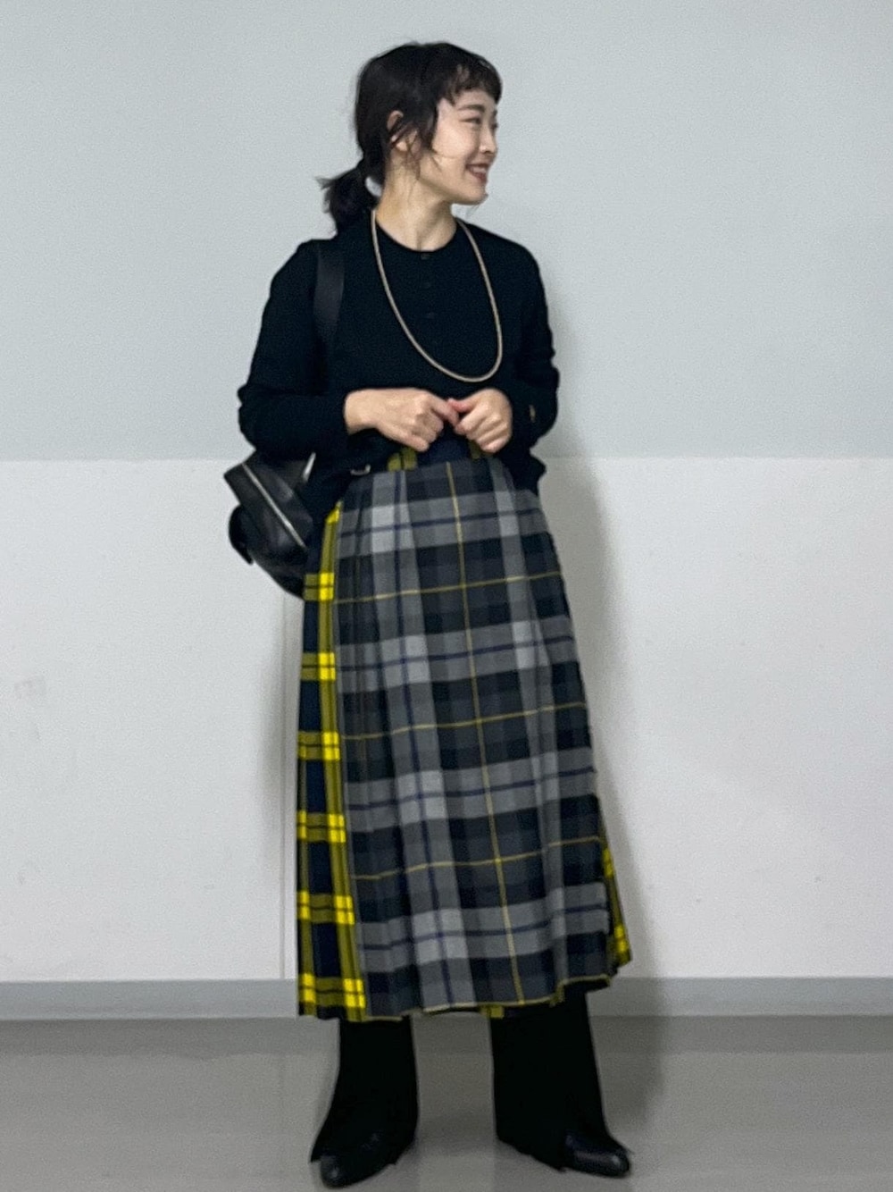 ブラック系のブーツ、グレー系のスカート、ブラック系のカーディガン/ボレロを着用したレディースの秋コーディネートの1枚目の写真