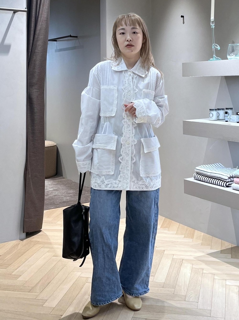 ブラック系のショルダーバッグ、ベージュ系のパンプス、ホワイト系のシャツ/ブラウスを着用したレディースの冬コーディネートの1枚目の写真