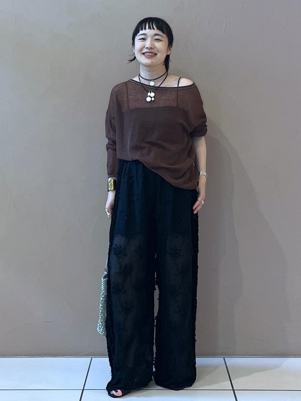 ブラック系のチューブトップ、ブラック系のサンダル、ブラウン系のカーディガン/ボレロを着用したレディースの夏コーディネートの1枚目の写真