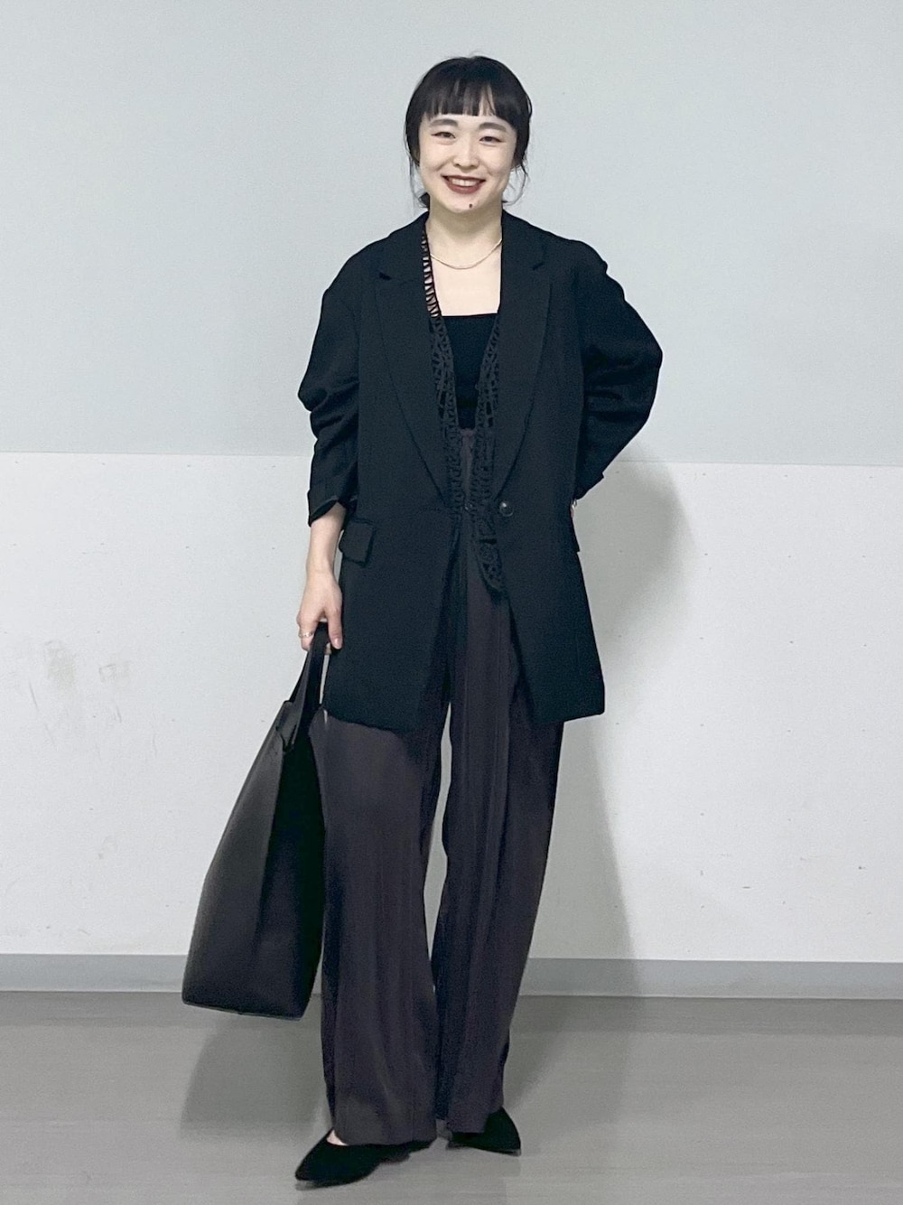 グレー系のその他パンツ、ブラック系のトートバッグを着用したレディースの春コーディネートの1枚目の写真