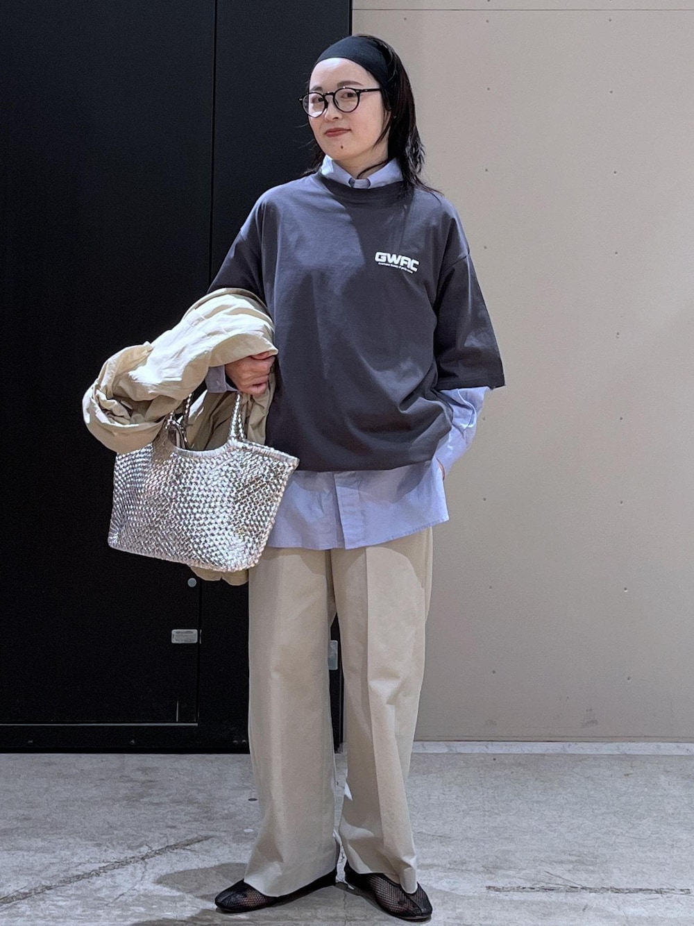 グレー系のスラックス、ベージュ系のブルゾン、ブラック系のパンプスを着用したレディースの春コーディネートの1枚目の写真