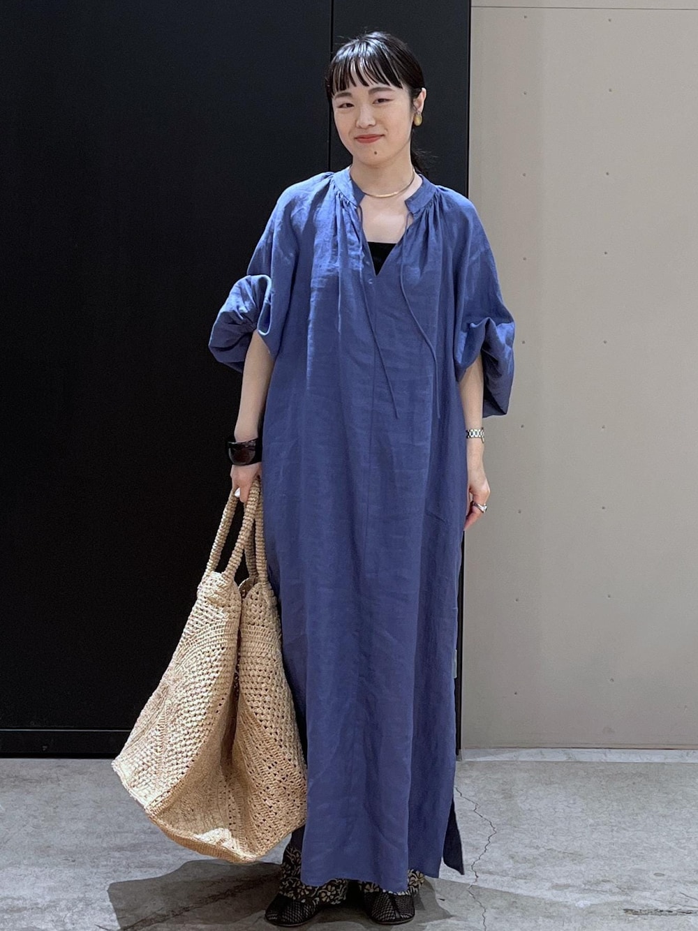 グレー系のその他パンツ、ホワイト系のかごバッグ、ブルー系のワンピースを着用したレディースの春コーディネートの1枚目の写真