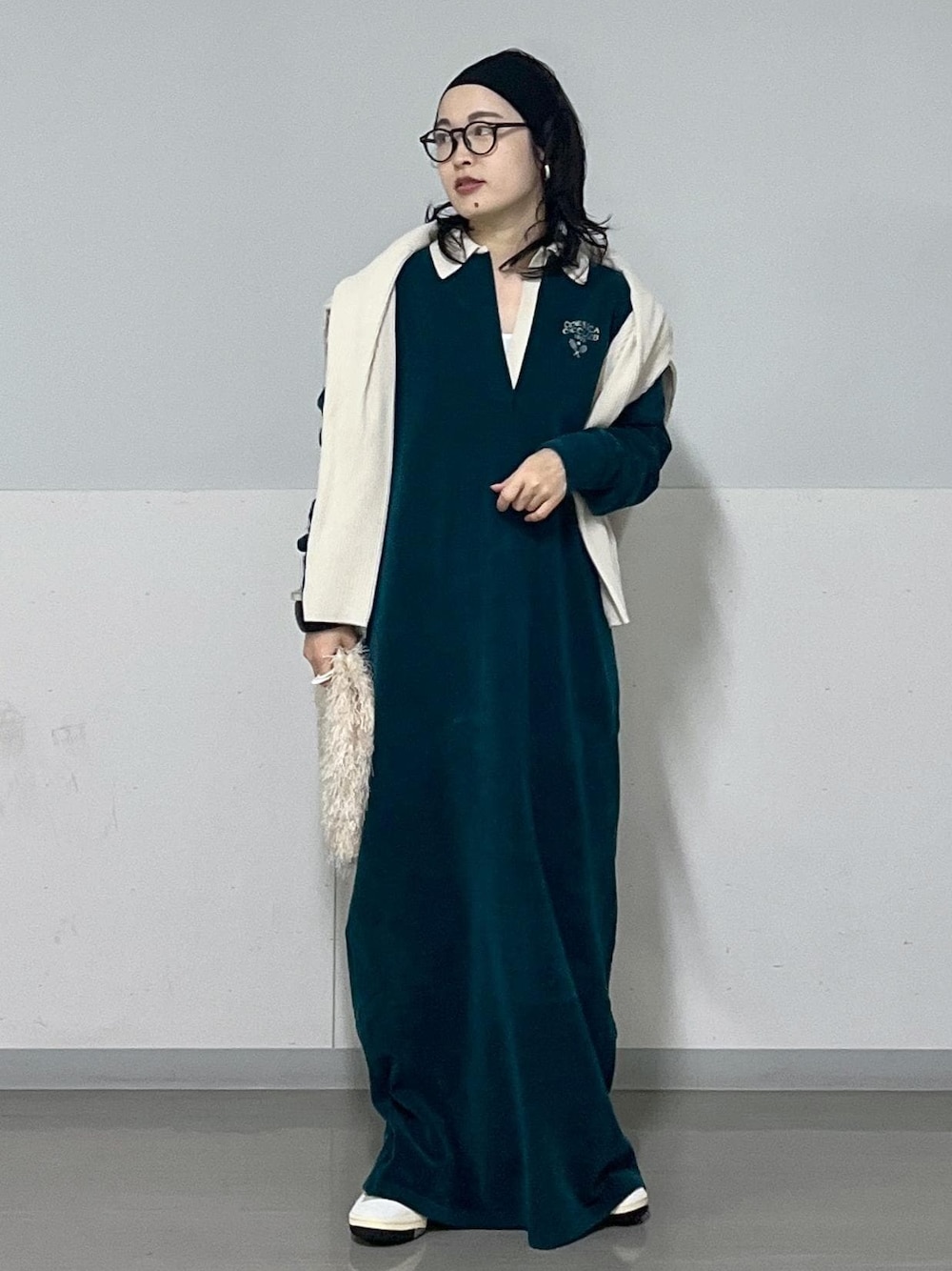 ホワイト系のハンドバッグ、ホワイト系のカーディガン/ボレロ、グリーン系のワンピースを着用したレディースの冬コーディネートの1枚目の写真