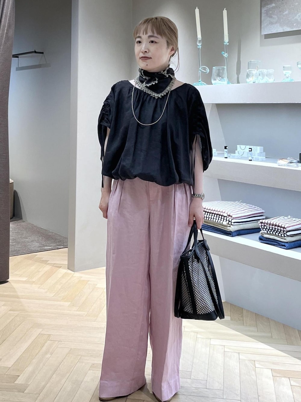 ピンク系のスラックス、ブラック系のトートバッグ、グレー系のシャツ/ブラウスを着用したレディースの春コーディネートの1枚目の写真