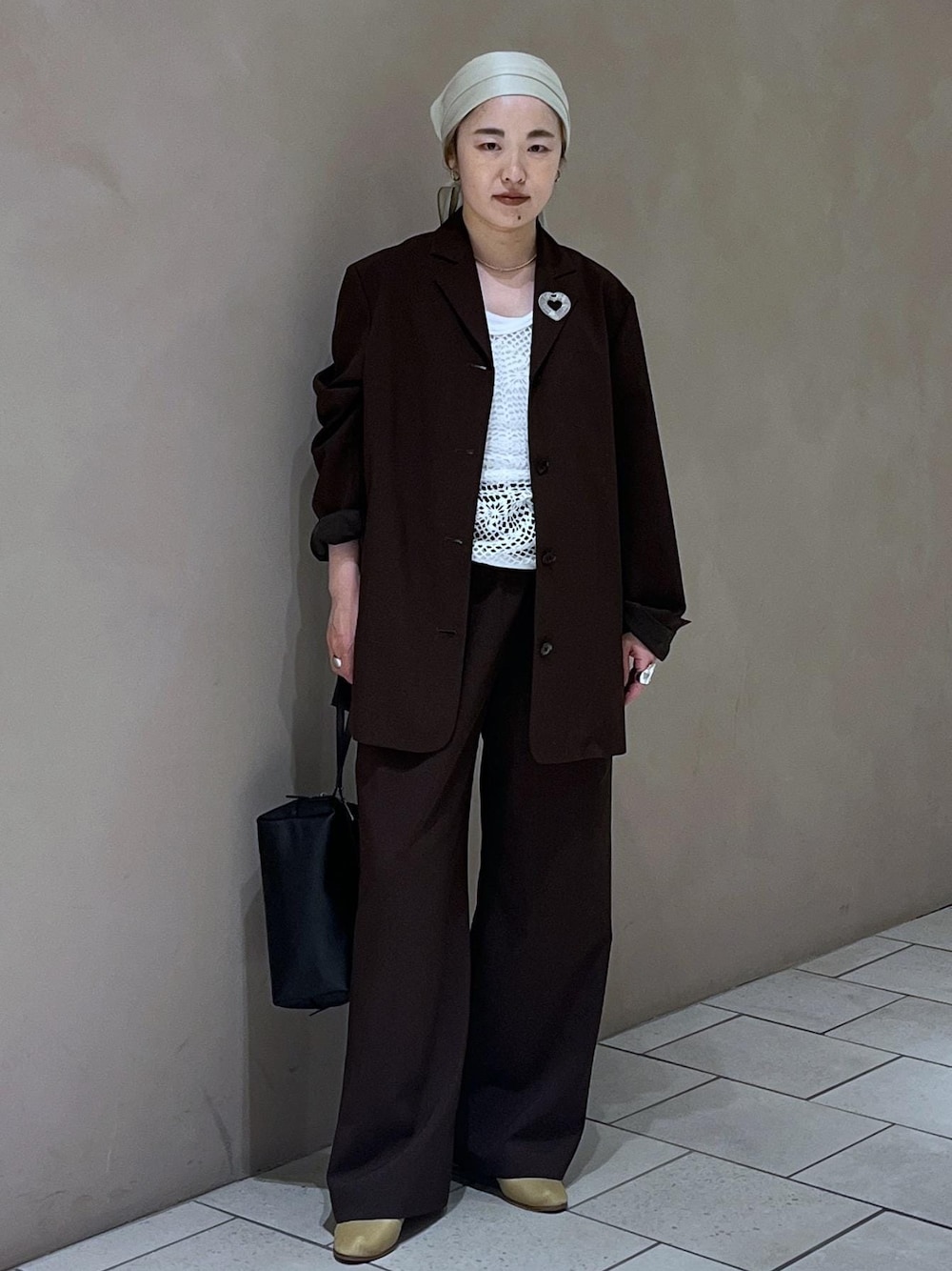 ブラック系のショルダーバッグ、ブラウン系のその他パンツ、ブラウン系のテーラードジャケットを着用したレディースの春コーディネートの1枚目の写真