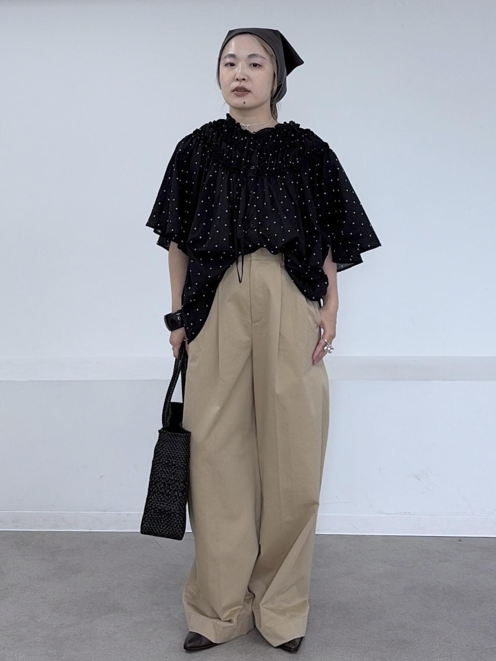 ベージュ系のその他パンツ、ブラック系のトートバッグ、ブラック系のシャツ/ブラウスを着用したレディースの夏コーディネートの1枚目の写真