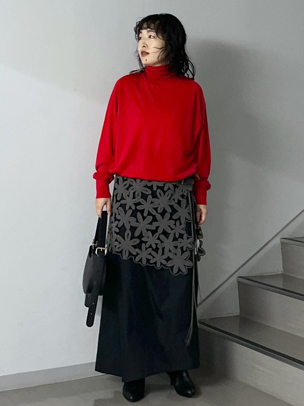 ブラック系のスカート、レッド系のニット/セーター、グレー系のスカートを着用したレディースの秋コーディネートの1枚目の写真