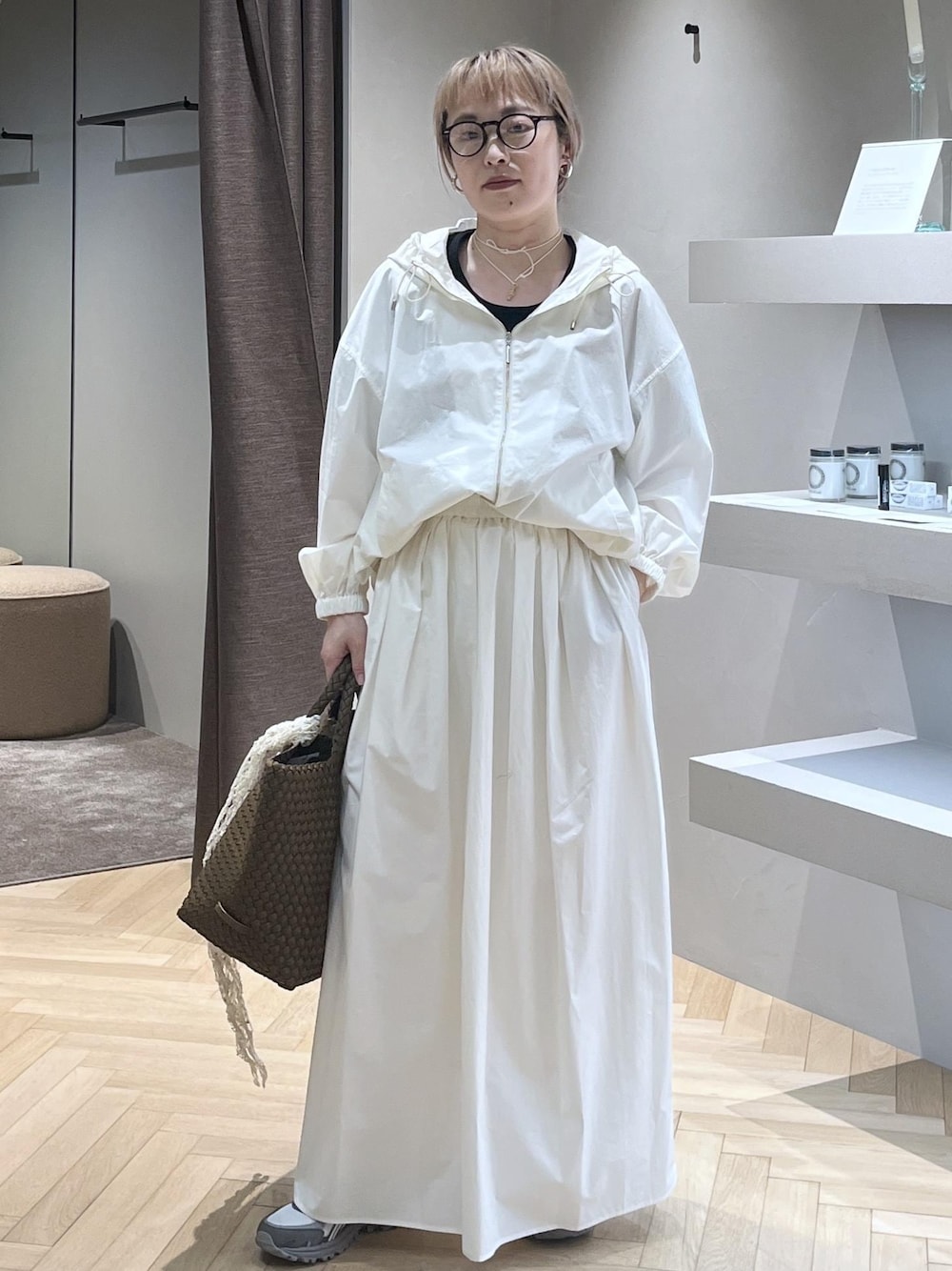 ホワイト系のブルゾン、ホワイト系のスカート、イエロー系のトートバッグを着用したレディースの春コーディネートの1枚目の写真