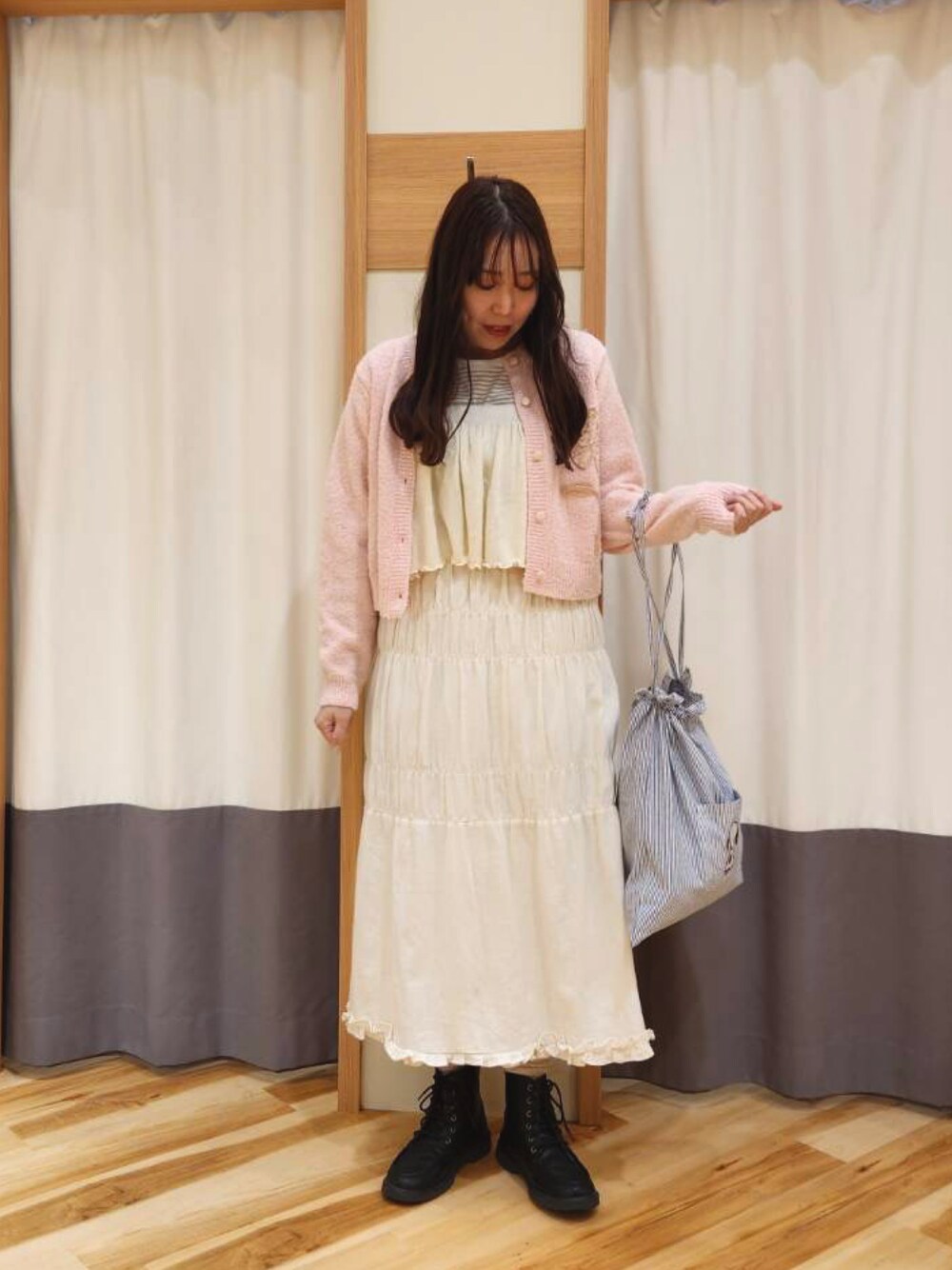 グレー系のTシャツ/カットソー、ピンク系のカーディガン/ボレロ、グリーン系のハンドバッグを着用したレディースの冬コーディネートの1枚目の写真