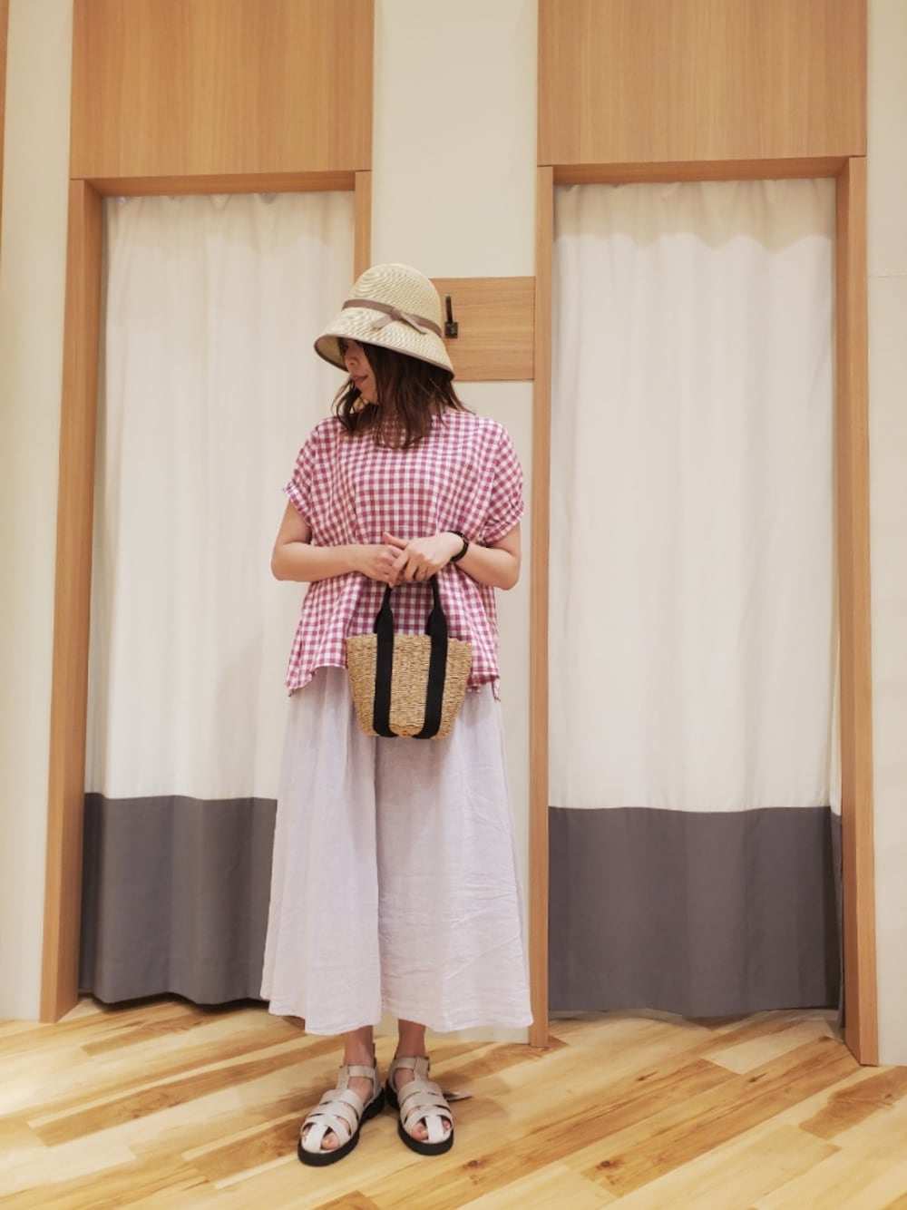 ホワイト系のサンダル、ピンク系のスカート、ブラック系のハンドバッグを着用したレディースの夏コーディネートの1枚目の写真