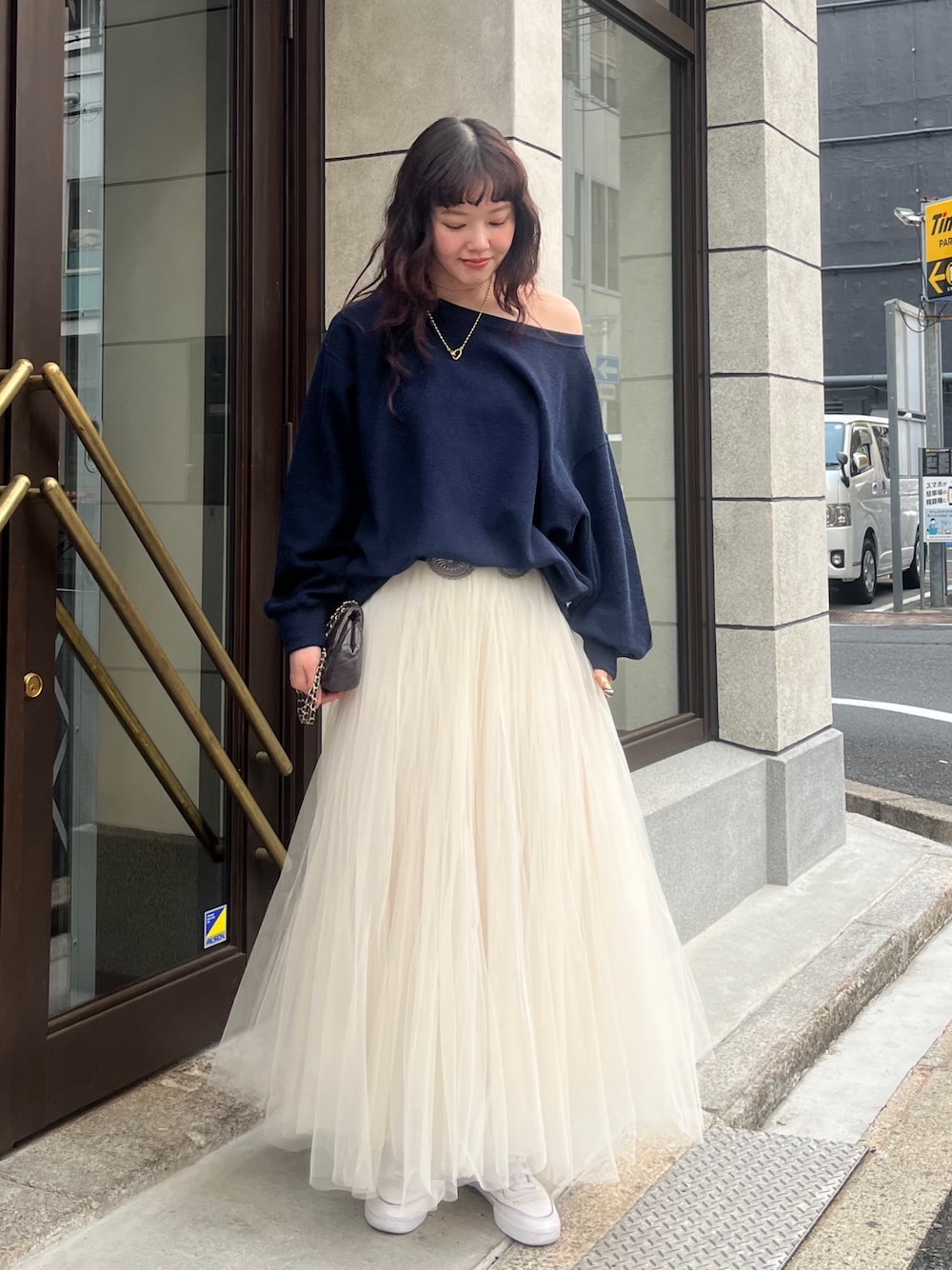 ホワイト系のスカート、ブルー系のTシャツ/カットソー、ブラック系のベルトを着用したレディースの冬コーディネートの1枚目の写真