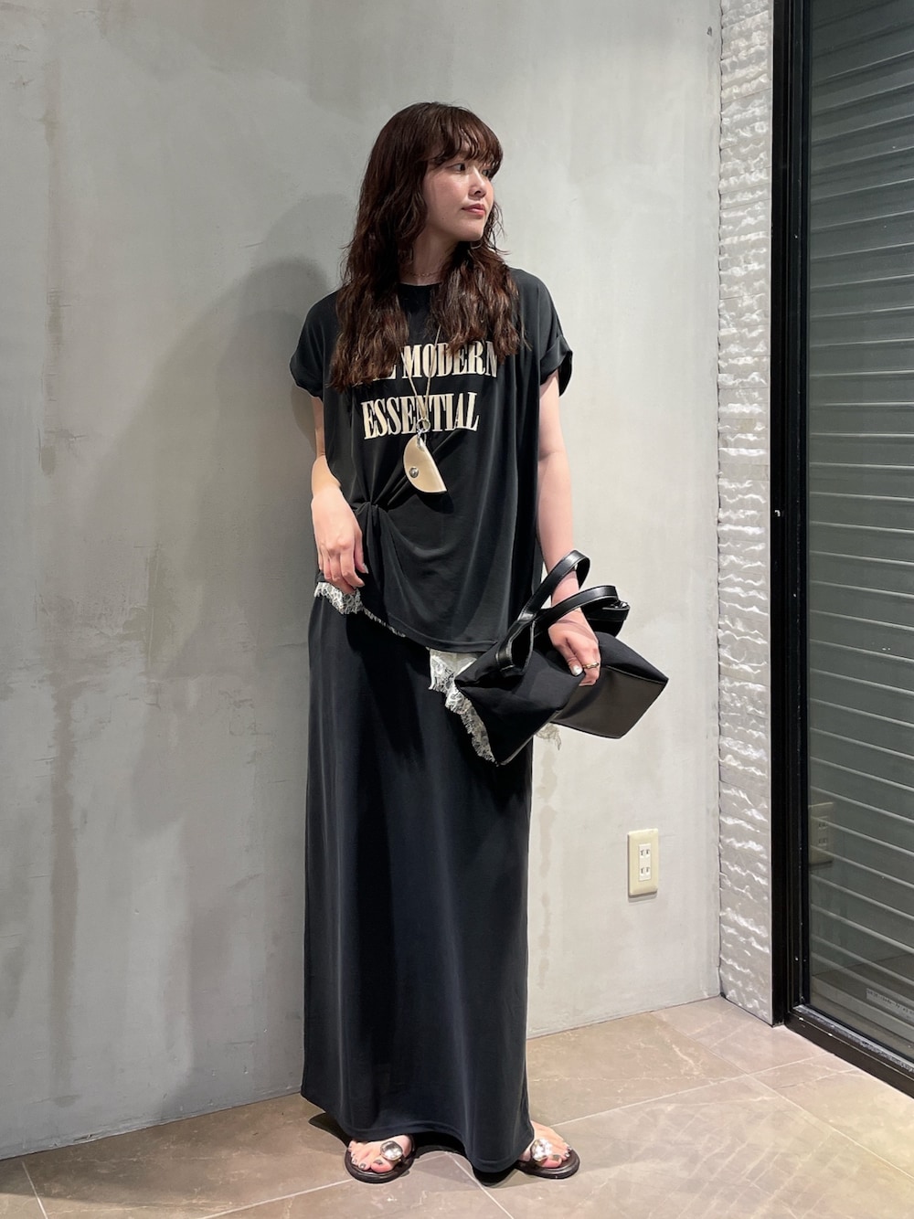 ブラック系のスカート、ホワイト系のシャツ/ブラウス、ブラック系のTシャツ/カットソーを着用したレディースの夏コーディネートの1枚目の写真