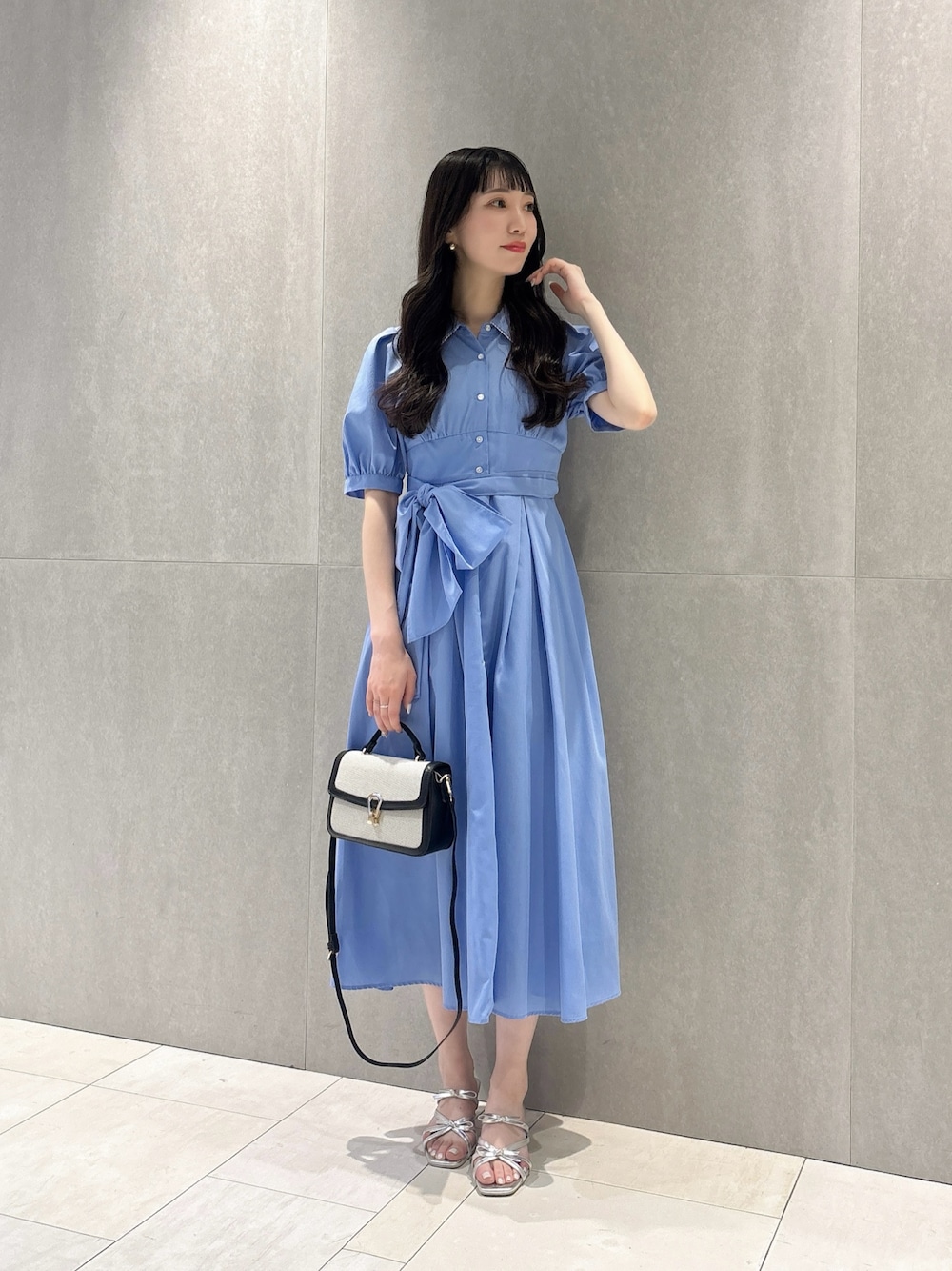 ブルー系のワンピース、ブラック系のショルダーバッグ、シルバー系のパンプスを着用したレディースの夏コーディネートの1枚目の写真