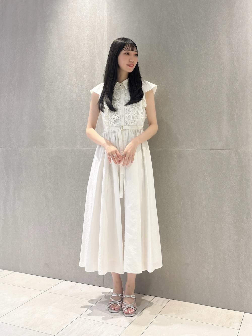 ホワイト系のワンピース、シルバー系のパンプスを着用したレディースの夏コーディネートの1枚目の写真