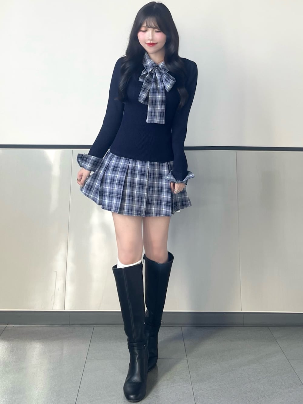 ブルー系のワンピース、ブラック系のブーツを着用したレディースの秋コーディネートの1枚目の写真