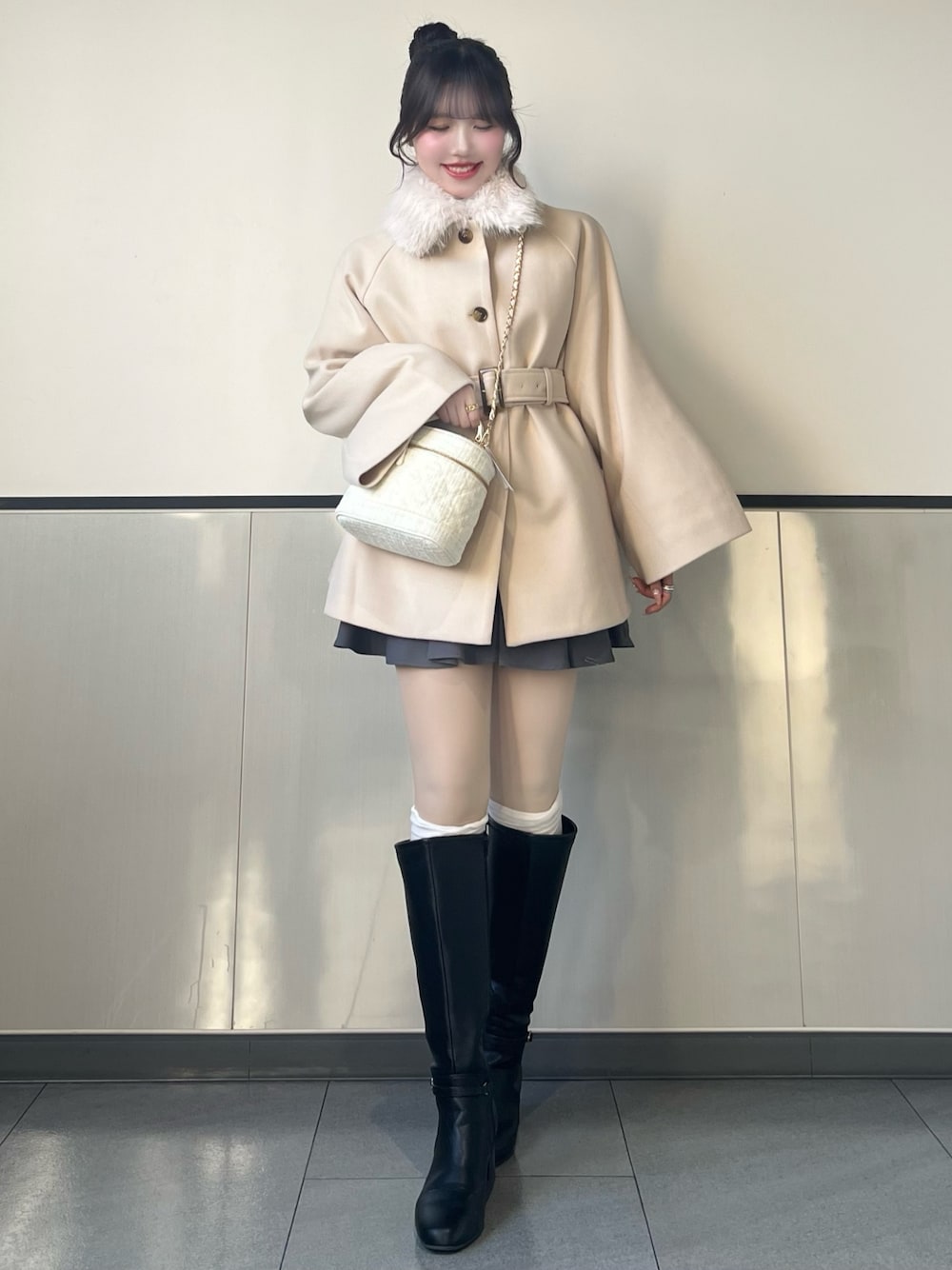 ホワイト系のその他アウター、ホワイト系のショルダーバッグ、グレー系のスカートを着用したレディースの秋コーディネートの1枚目の写真