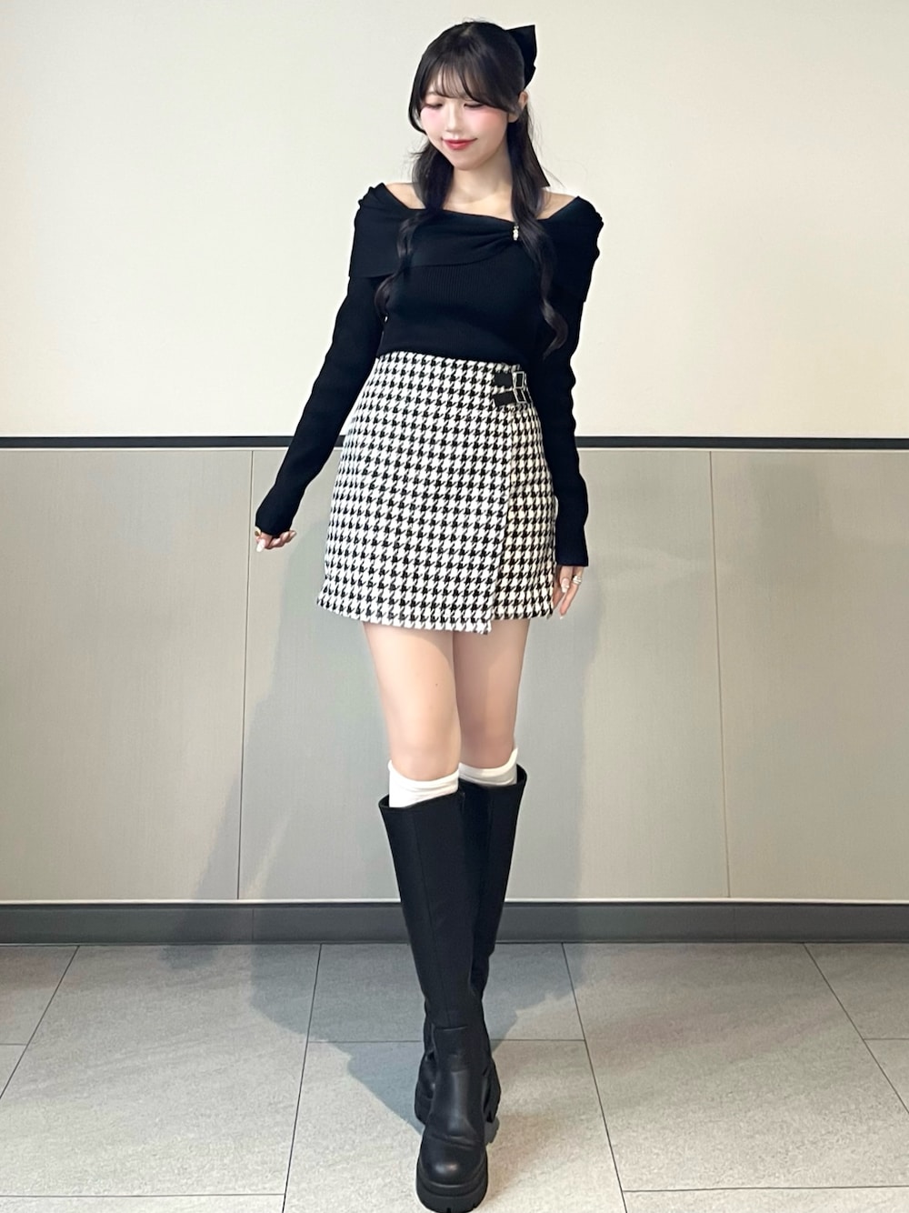 ブラック系のニット/セーター、その他のスカート、ブラック系のブーツを着用したレディースの秋コーディネートの1枚目の写真