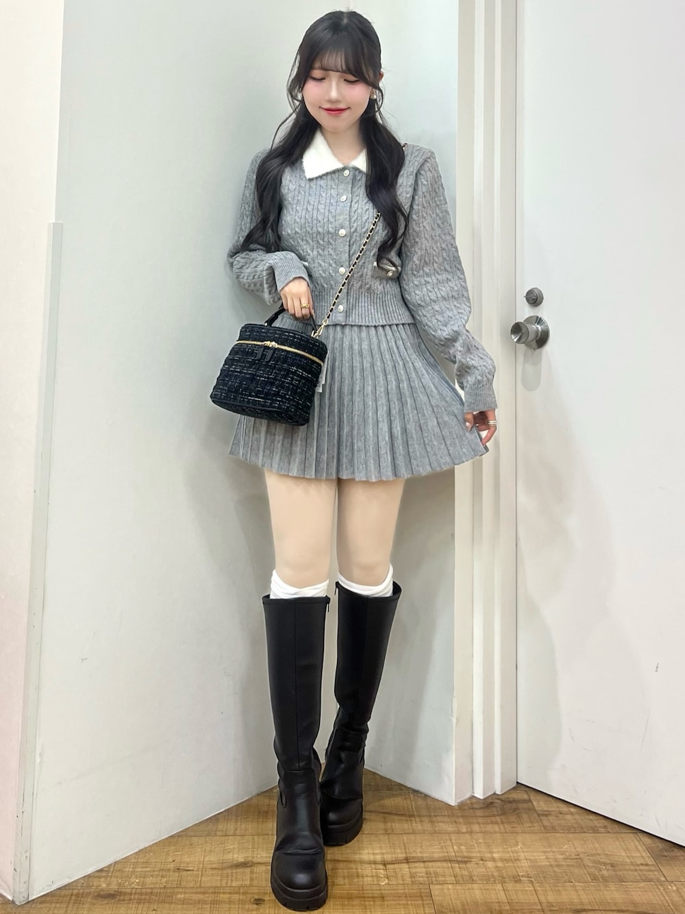 グレー系のカーディガン/ボレロ、ブラック系のショルダーバッグ、ブラック系のブーツを着用したレディースの冬コーディネートの1枚目の写真