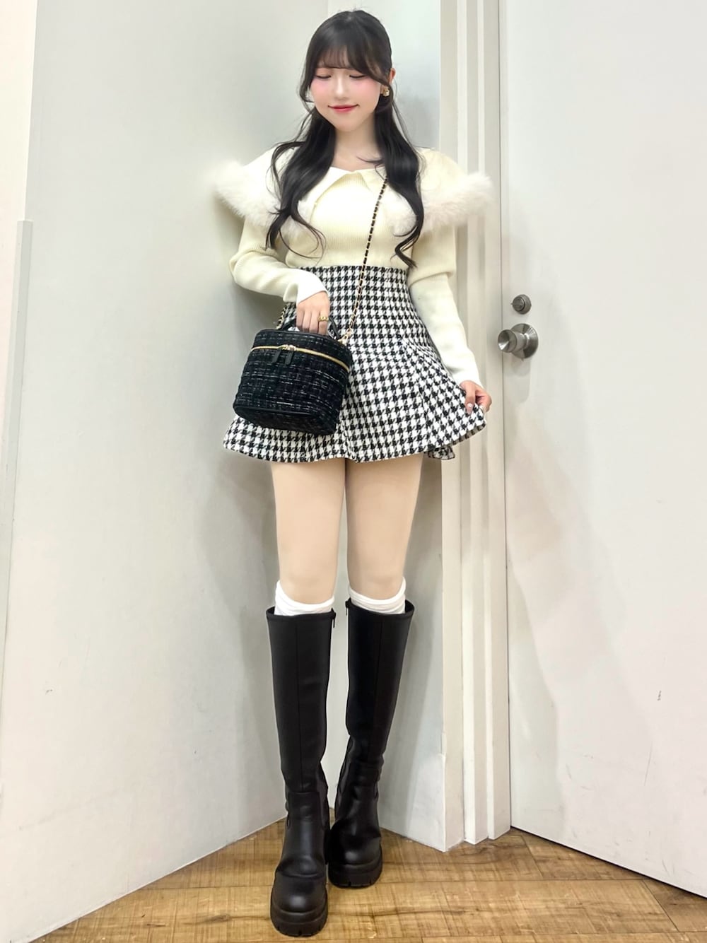 ホワイト系のニット/セーター、その他のスカート、ブラック系のショルダーバッグを着用したレディースの冬コーディネートの1枚目の写真