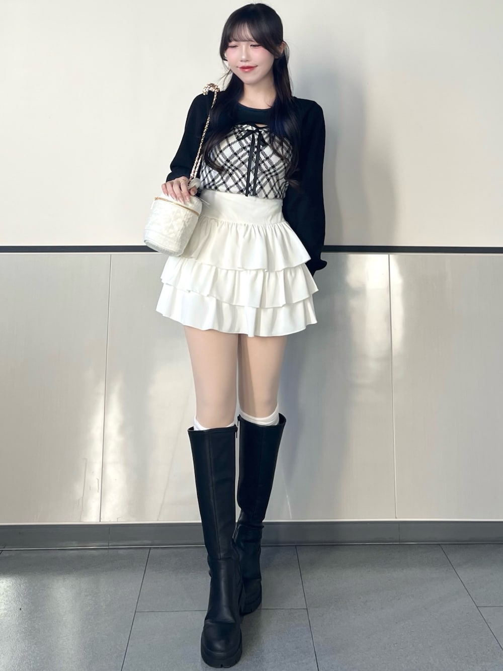 ホワイト系のニット/セーター、ホワイト系のスカート、ホワイト系のショルダーバッグを着用したレディースの秋コーディネートの1枚目の写真