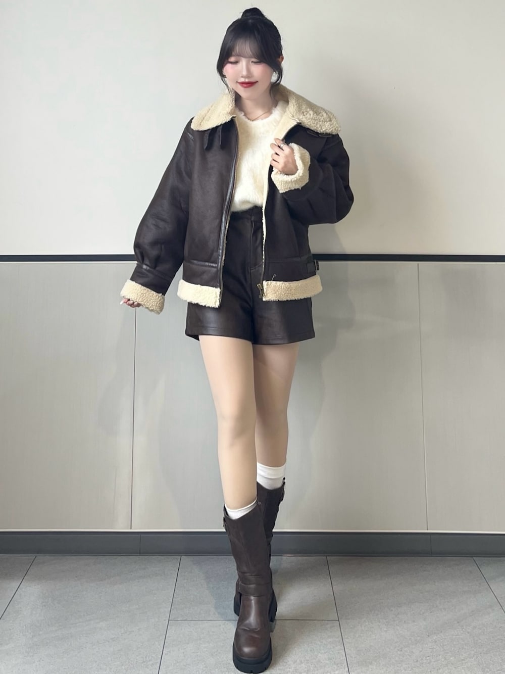 ブラウン系のブルゾン、ホワイト系のニット/セーター、ブラウン系のその他パンツを着用したレディースの秋コーディネートの1枚目の写真