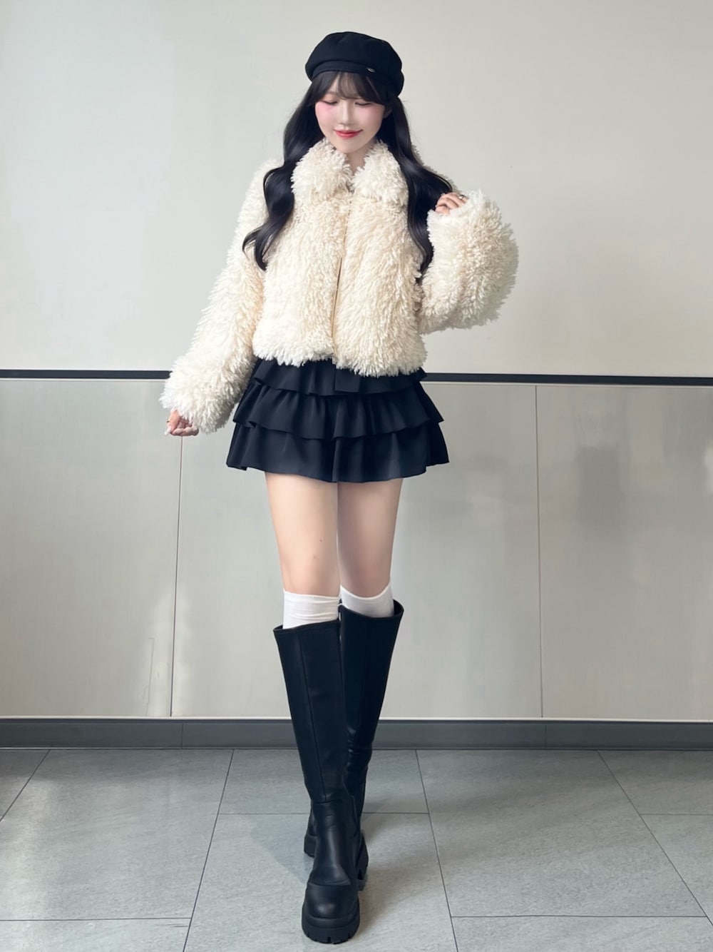 ホワイト系のブルゾン、ブラック系のスカート、ブラック系のブーツを着用したレディースの秋コーディネートの1枚目の写真