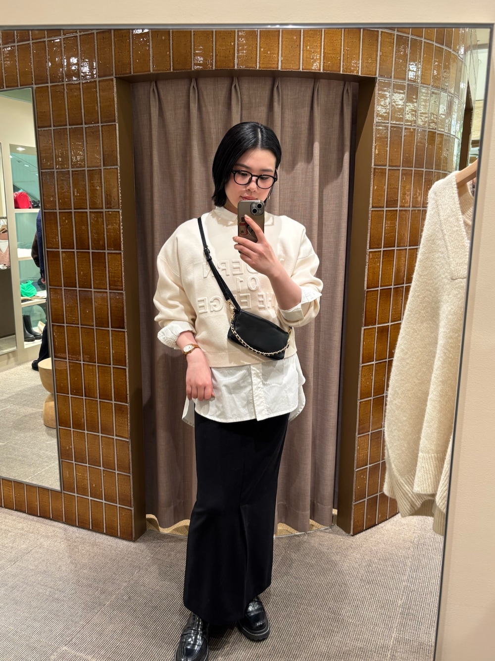 ホワイト系のニット/セーター、ホワイト系のシャツ/ブラウス、ブラック系のスカートを着用したレディースの冬コーディネートの1枚目の写真