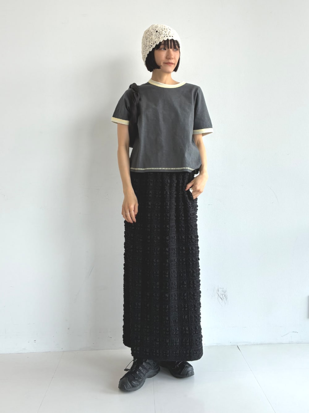 ブラック系のスカート、グレー系のTシャツ/カットソーを着用したレディースの春コーディネートの1枚目の写真