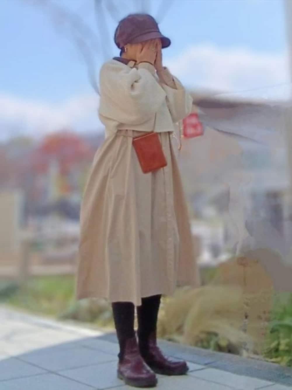 ベージュ系のシャツワンピース、ブラウン系のブーツ、ホワイト系のニット/セーターを着用したレディースの冬コーディネートの1枚目の写真