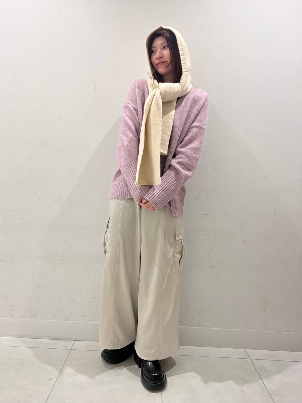 ブラック系のブーツ、ピンク系のカーディガン/ボレロ、ベージュ系のその他パンツを着用したレディースの冬コーディネートの1枚目の写真