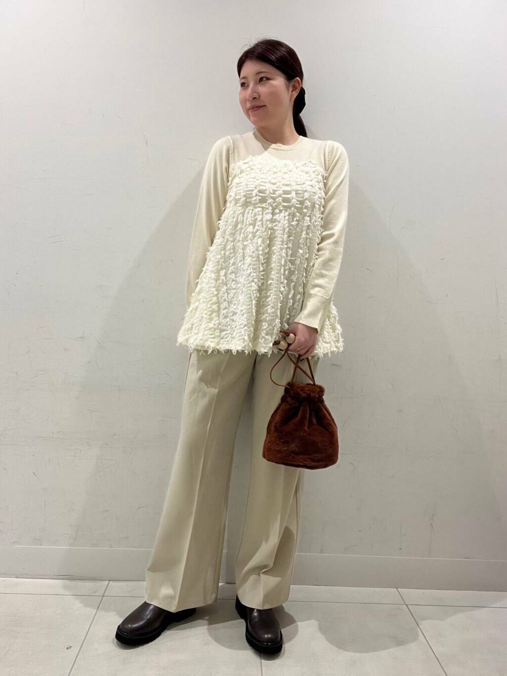 ベージュ系のその他パンツ、ブラウン系のブーツ、ブラウン系のショルダーバッグを着用したレディースの冬コーディネートの1枚目の写真