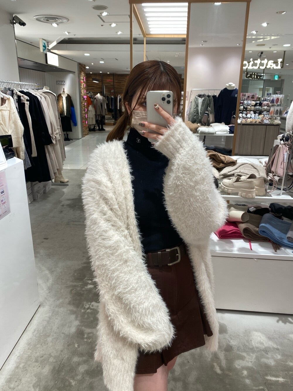 ブラウン系のスカート、ホワイト系のカーディガン/ボレロ、ブラック系のTシャツ/カットソーを着用したレディースの秋コーディネートの1枚目の写真