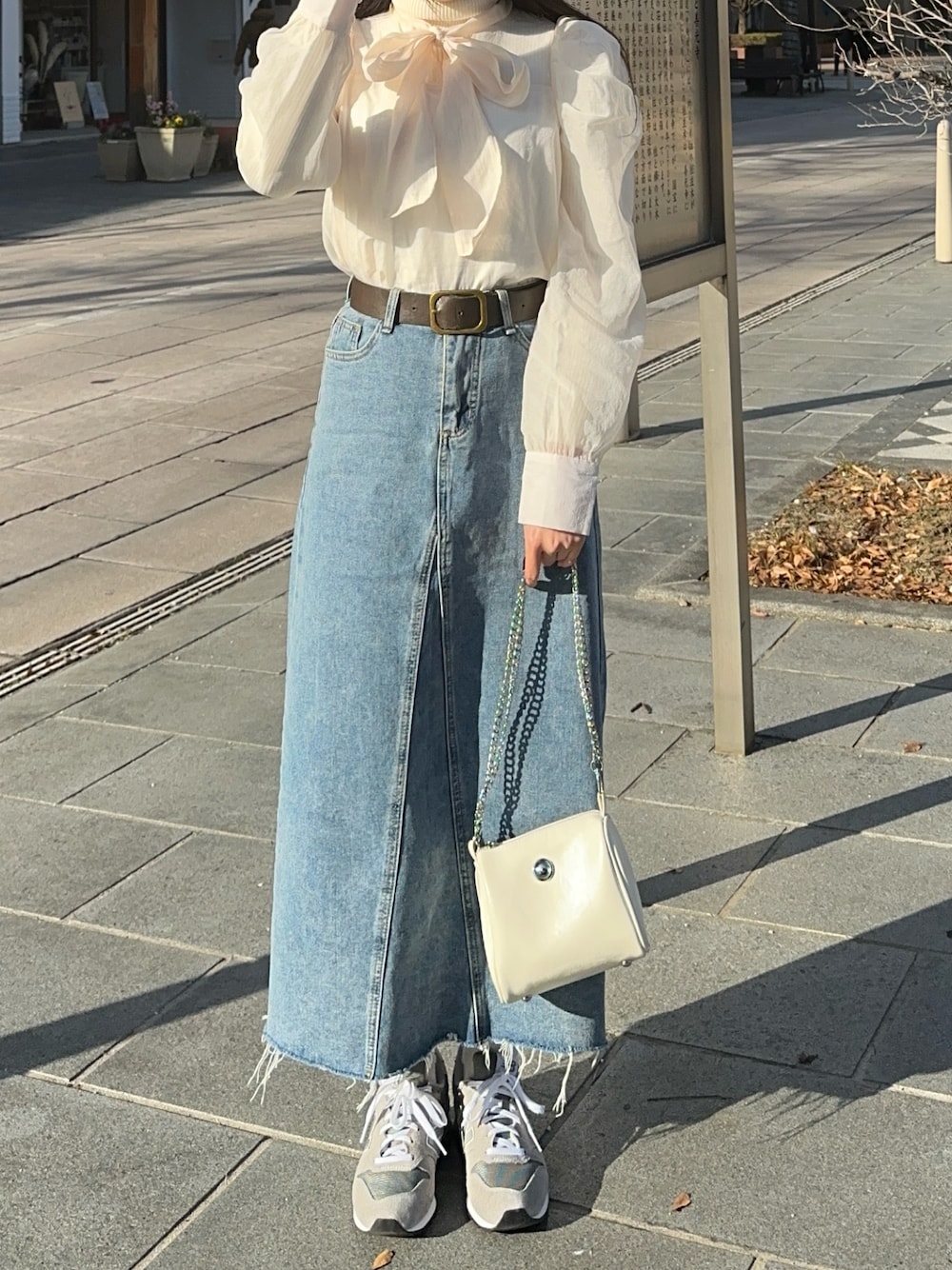 ホワイト系のシャツ/ブラウス、ホワイト系のショルダーバッグ、グレー系のスニーカーを着用したレディースの冬コーディネートの1枚目の写真