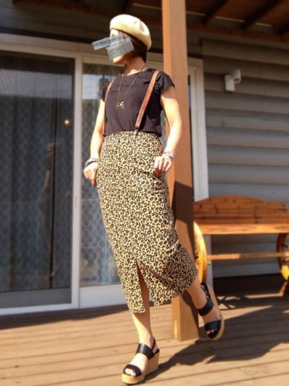 ブラウン系のデニムスカート、ブラック系のサンダル、ブラック系のTシャツ/カットソーを着用したレディースの夏コーディネートの1枚目の写真