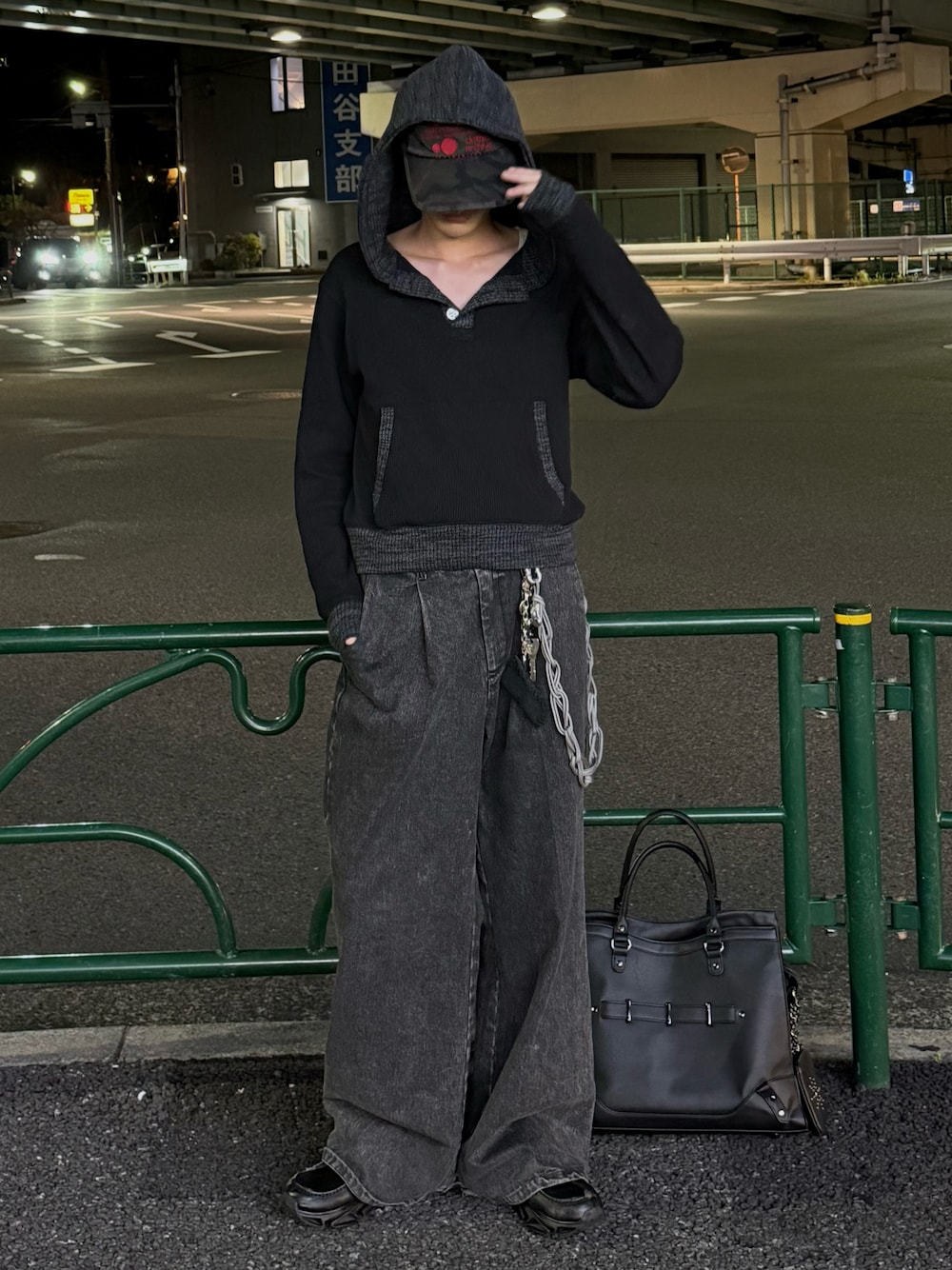 ブラック系のパーカー、グレー系のデニムパンツ、ブラック系のボストンバッグを着用したメンズの秋コーディネートの1枚目の写真
