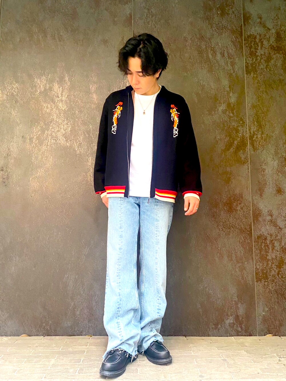 ブルー系のデニムパンツ、ブラック系のブーツ、ホワイト系のTシャツ/カットソーを着用したメンズの春コーディネートの1枚目の写真