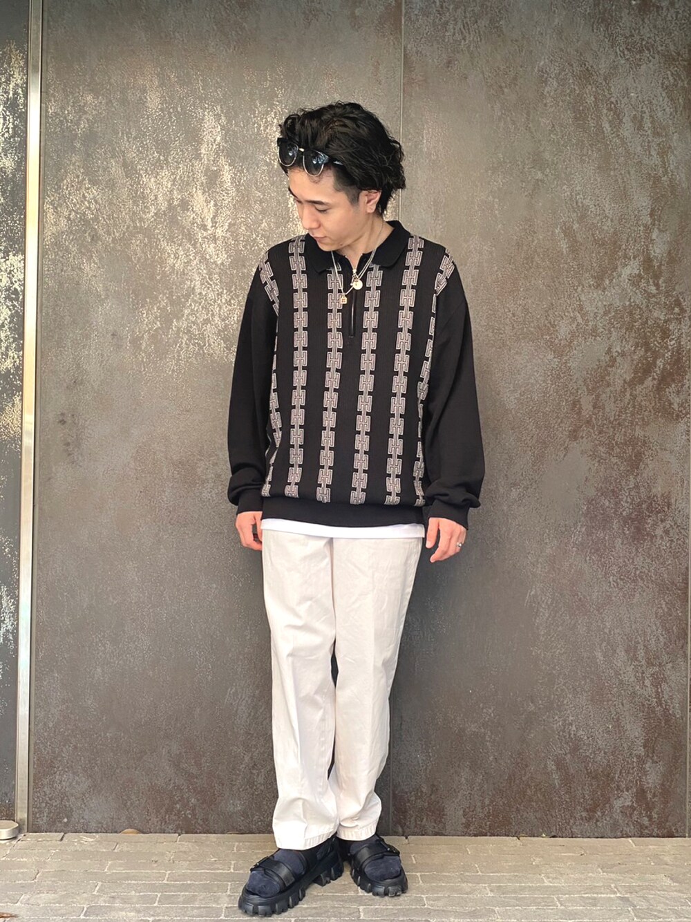 ブラック系のニット/セーター、ホワイト系のタンクトップ、グレー系のその他パンツを着用したメンズの春コーディネートの1枚目の写真