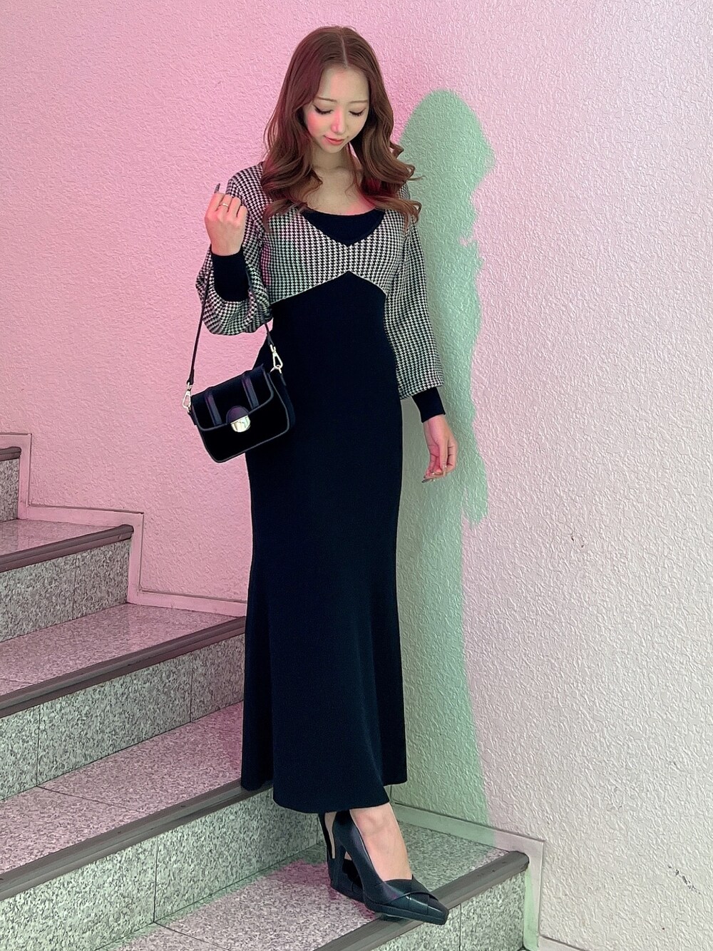 ブラック系のワンピース、ブラック系のパンプス、ブラック系のショルダーバッグを着用したレディースの冬コーディネートの1枚目の写真